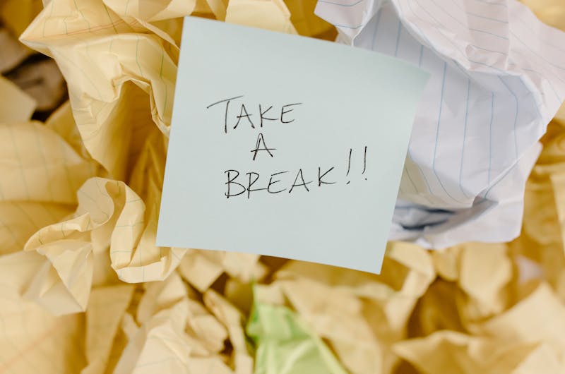 Sticky note with 'Take a Break' on crumpled paper background.